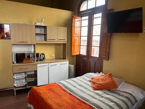 Una pequeña cocina con una cama en una habitación en La Casona de Palacio Viejo, en Arequipa