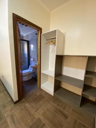 a room with a bathroom with a toilet and a closet at Residencial Victoria Said in Linares