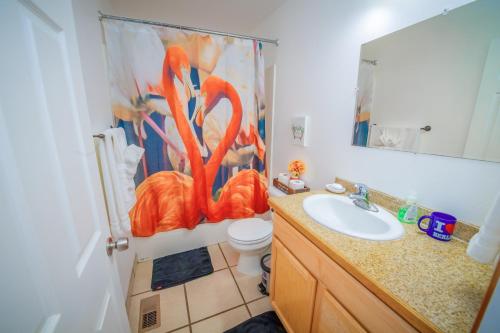 baño con lavabo y una pintura naranja en la pared en Cute Artsy7 Getaway, large parking, 20mins to OSU, en Albany