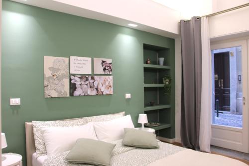 um quarto com paredes verdes e uma cama com duas almofadas em Casa Canelli em Turim