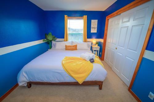 Un dormitorio azul con una cama con una manta amarilla. en Cute Artsy7 Getaway, large parking, 20mins to OSU, en Albany