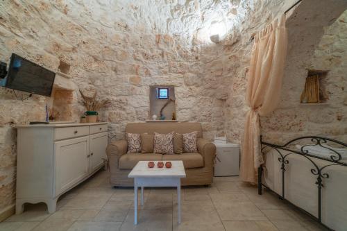 een woonkamer met een bank en een tafel bij Trullo Lauro in Ceglie Messapica