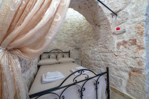 een kleine slaapkamer met een bed in een stenen muur bij Trullo Lauro in Ceglie Messapica