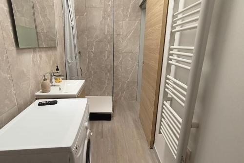 a bathroom with a white sink and a shower at Appart proche palais justice in Angoulême