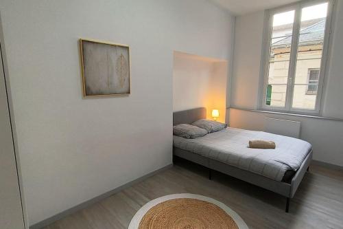 a small bedroom with a bed and a window at Appart proche palais justice in Angoulême