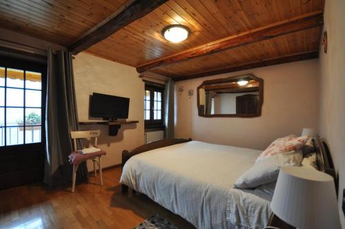 a bedroom with a bed and a flat screen tv at Cat Marvei in Villadossola