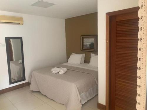 um quarto com uma cama com uma toalha em Espaço Hale Kai em Guarapari
