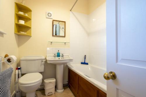 La salle de bains est pourvue de toilettes, d'un lavabo et d'une baignoire. dans l'établissement Garden Cottage Haughton Castle, à Hexham