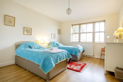 - 2 lits dans une chambre avec fenêtre dans l'établissement Garden Cottage Haughton Castle, à Hexham