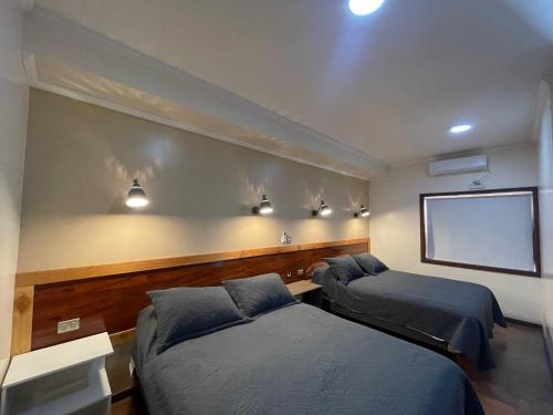 a room with two beds and lights on the wall at Residencial Victoria Said in Linares