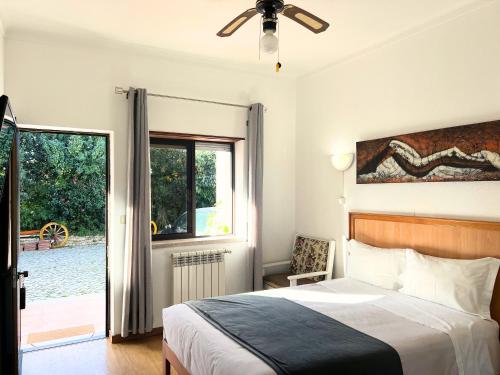 a bedroom with a bed and a view of a pool at Costa Brava Alojamento in Benedita