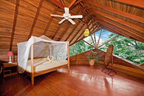 a bed room with a bed with a canopy on top of it at Tree House Lodge in Puerto Viejo