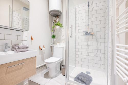 La salle de bains est pourvue de toilettes et d'une douche en verre. dans l'établissement Le PETIT JEAN, à Nice