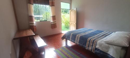 una camera con letto e finestra aperta di Lucmabamba Lodge a Santa Teresa