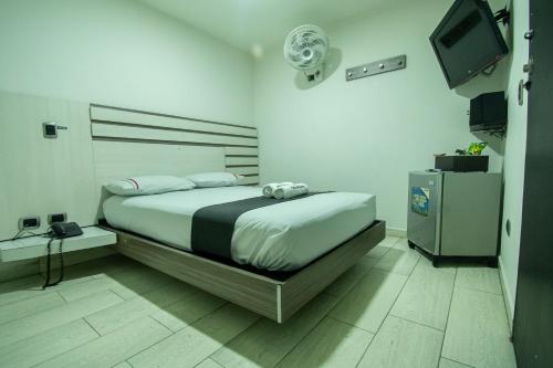 a bedroom with a bed with a television and a bedskirtspectspectspectspects at Hotel Panorama Medellín in Medellín