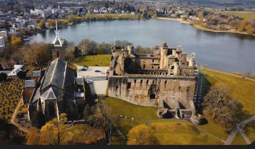 an old castle sitting on the edge of a lake at Caledonia House in Rosyth