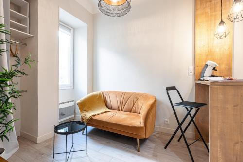 salon ze skórzanym krzesłem i dwoma stołami w obiekcie Le PETIT JEAN w Nicei