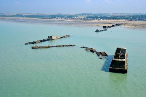 a group of bays in the water next to a beach at Les mouettes Apt duplex indépendant dans maison spacieux petite vue sur mer des chambres belle terrasse aménagée en hauteur près Omaha Beach et Bayeux 800 m plage et 300 m superette in Vierville-sur-Mer