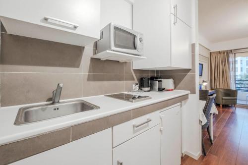 une cuisine avec un évier et un micro-ondes dans l'établissement Wdf studio right in the heart of Cannes!!, à Cannes
