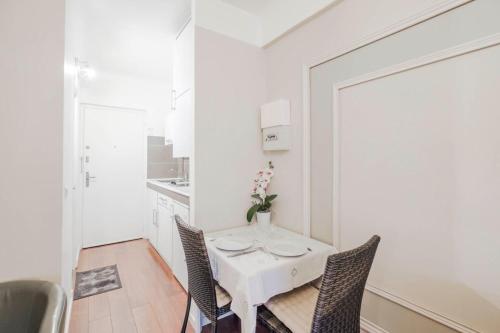 une salle à manger blanche avec une table et des chaises blanches dans l'établissement Wdf studio right in the heart of Cannes!!, à Cannes