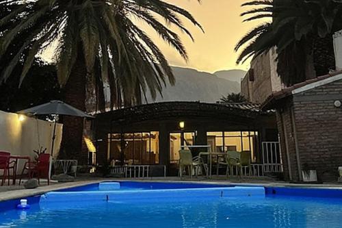 una gran piscina azul junto a una casa en Hotel REAL CAFAYATE en Cafayate