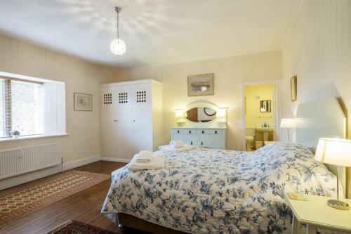 1 dormitorio con cama, mesa y ventana en Garden Cottage Haughton Castle 2 en Hexham