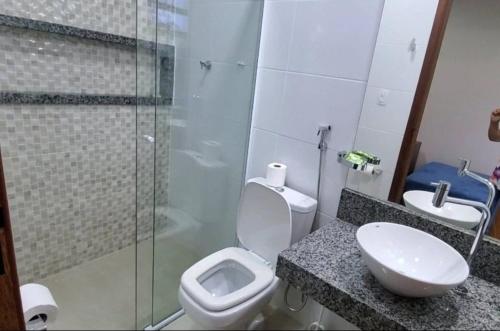 a bathroom with a toilet and a sink and a shower at Apartamento em São Pedro, prédio novo 402 in Juiz de Fora