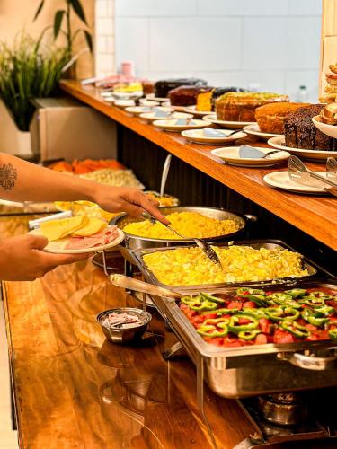 a buffet line with many different types of food at HMG Rio Suítes in Rio de Janeiro