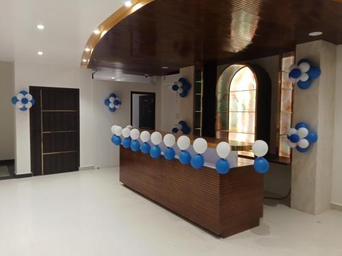 een kamer met een balie met blauwe en witte ballonnen bij Hotel JVW Arena in Motīhāri