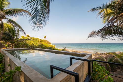 a plunge pool with the beach in the background at Tropicalito Villa on the Beach in Tulum