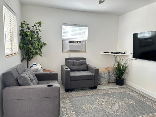 a living room with a couch and a chair and a tv at EBBTIDE INN in St Pete Beach