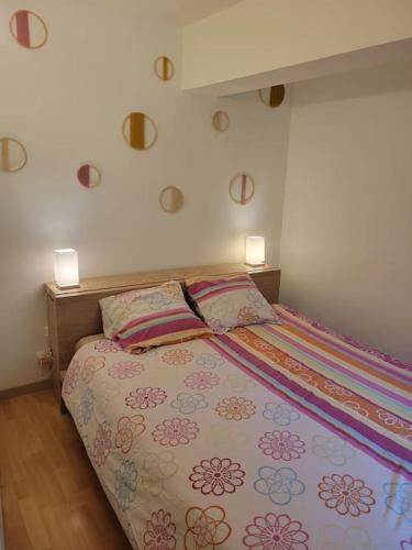 un lit dans une chambre avec deux lampes au mur dans l'établissement Dumur - centre ville Evian, à Évian-les-Bains