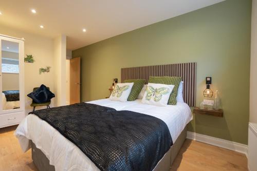 um quarto com uma cama grande e paredes verdes em The Links Suites em Newcastle