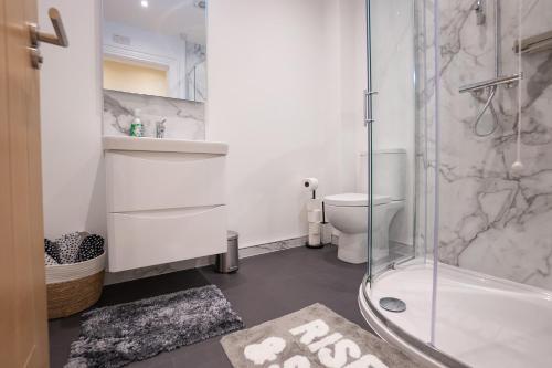 uma casa de banho com um chuveiro, um lavatório e um WC. em The Links Suites em Newcastle