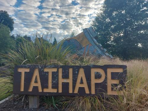 a sign in the middle of a field with a slide at DuxHouse BnB in Taihape