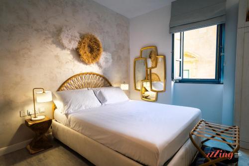 ein Schlafzimmer mit einem weißen Bett und einem Fenster in der Unterkunft Avalon Boutique in Valletta