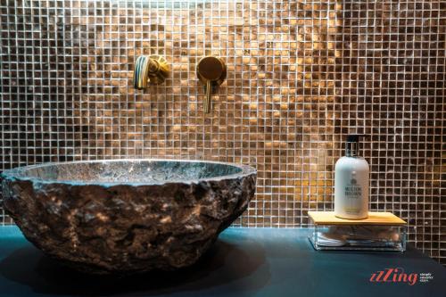 a bathroom with a stone sink with a bottle of soap at Avalon Boutique in Valletta