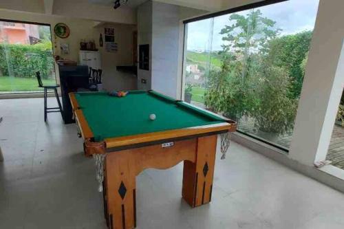 a pool table in a room with a large window at Casa dos Colibris, Lugar memorável! in Chã Grande