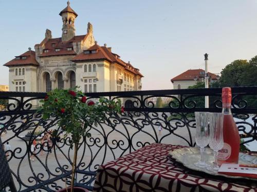 a table with a bottle of wine sitting on a balcony at Boutique ALNIS in Constanţa