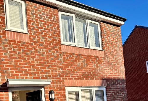 a red brick building with white windows on it at Ensuite Room with free parking 