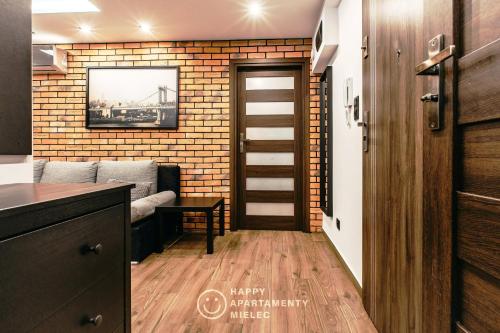 a living room with a brick wall at Happy - ApartamentyHappy pl in Mielec