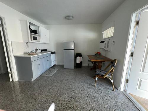 a white kitchen with a table and a refrigerator at EBBTIDE INN in St Pete Beach