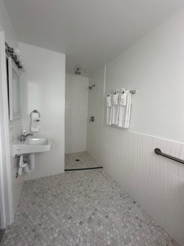 a white bathroom with a sink and a mirror at EBBTIDE INN in St Pete Beach