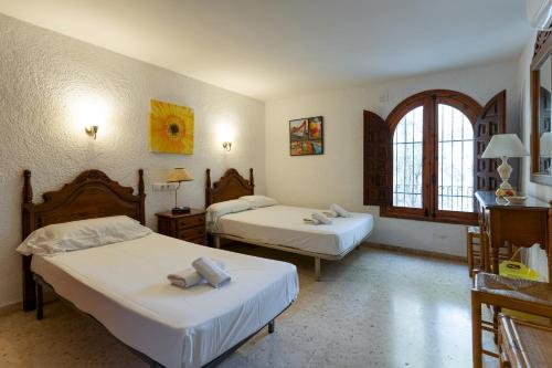 a hotel room with two beds and a window at Villa Rosa in Jávea