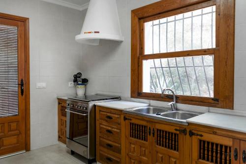 cocina con fregadero y ventana en Villa Rosa, en Jávea
