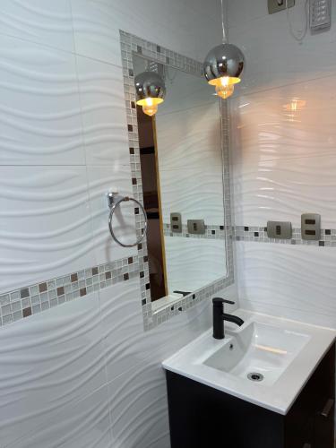 a bathroom with a sink and a mirror at Residencial Victoria Said in Linares