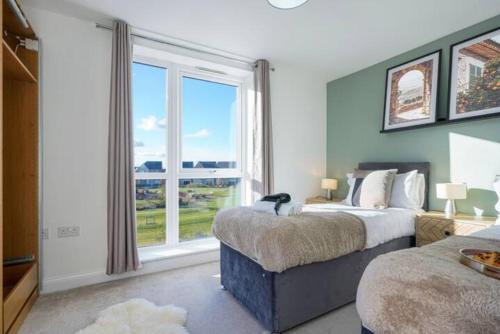 ミルトン・キーンズにあるStunning 4 Bedroom 2 Bathroom House - Close to City Centre - Sleeps 8 - Free Parking, Super-Fast Wifi and Smart TVs by Yoko Propertyのベッドが2つと大きな窓がある寝室