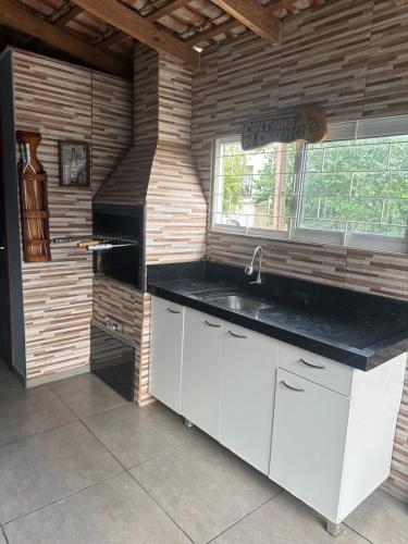 a kitchen with a sink and a window at Aluga-se casa para Show rural in Cascavel