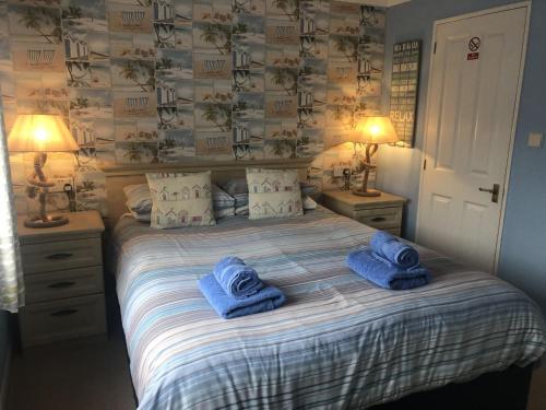 a bedroom with a bed with blue towels on it at Luke's Lodge in Newton Abbot