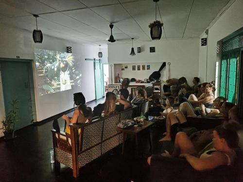 um grupo de pessoas sentadas numa sala assistindo a uma apresentação em The Lost Hostels, Weligama Beach - Sri Lanka em Weligama